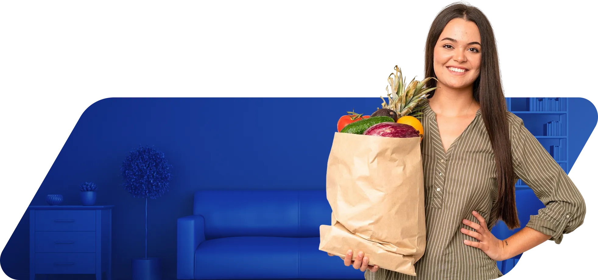 Mulher sorridente segura uma sacola de papel com frutas e verduras, em frente a um fundo azul com sofá e estante.